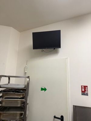 une photo d'une chambre d'hôpital avec une télévision accrochée au mur