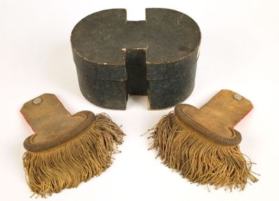 une paire de brosses en bois à franges posées sur une surface blanche