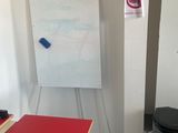 a red table and a white board in a room