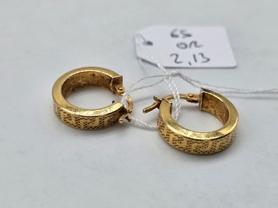 deux paires de boucles d'oreilles en or sur fond blanc