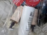 a lot of beauty products in a plastic bag on a bed