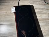 a black stove top with two burners on it