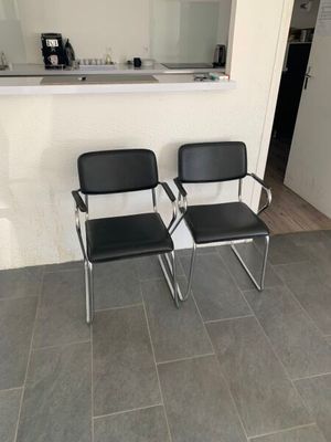 deux chaises noires placées devant un miroir