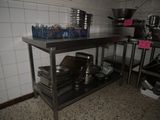 many pots and pans on a metal shelf in the kitchen