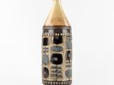 a brown and black vase sitting on a white surface