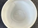 a white cup with a handle sitting on the floor