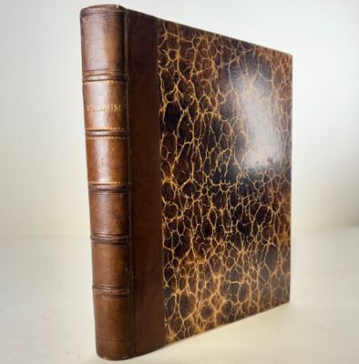an old book with a brown cover sitting on top of a table