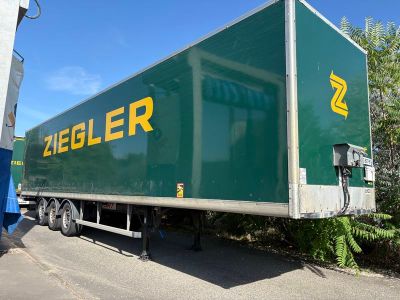 un gros camion vert garé sur le bord de la route