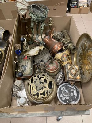 une boîte remplie d'objets hétéroclites posée sur le sol