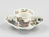 a small cup and saucer with a design on it