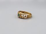 a close up of a gold ring with a green stone