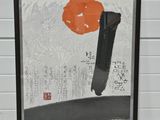 tableau représentant une fleur d'oranger dans un cadre noir, sur fond de mur de briques blanches