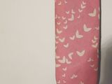 a ironing board with a pink cover and a pair of shoes next to it