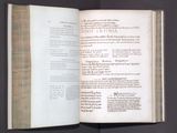 an open book on a table with a black background