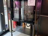 une machine sur laquelle est apposée une affiche, devant une vitrine