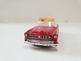 a red toy car that is on a white surface