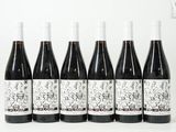 six bouteilles de vin sont alignées sur une surface blanche