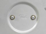 a close up of a white plate with two buttons on it