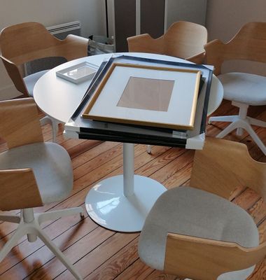 several chairs and a table in a room with a picture on the table