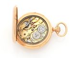 a close up of a pocket watch on a white surface
