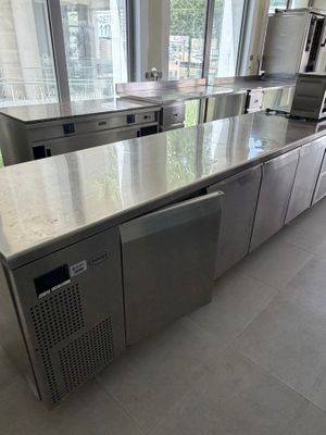 une grande cuisine équipée d'appareils électroménagers en inox et dotée d'une grande fenêtre