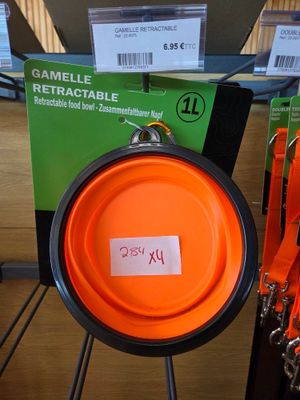 an orange frisbee hanging from a rack in a store