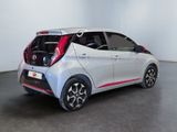 the rear end of a silver and red car parked in a room