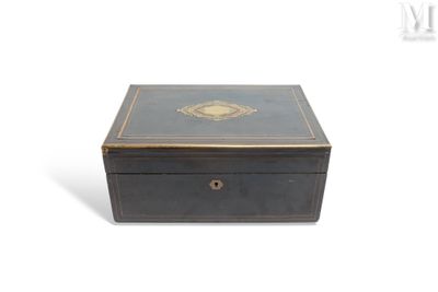 une vieille boîte noire ornée d'un médaillon doré sur le couvercle