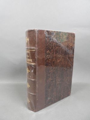 an old book sitting on top of a white table next to a white wall