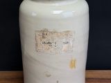 a white vase sitting on top of a wooden table