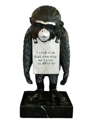 statue of a gorilla holding a sign with a sign on it ' s back