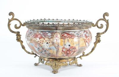 a decorative bowl with a metal handle on a stand