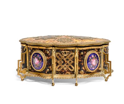 a gold and blue box on a stand on a white surface