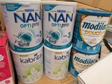 several containers of baby formulas are stacked on a counter