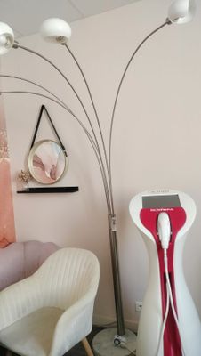a picture of a living room with a white chair and a red and white floor lamp