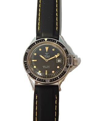an image of a wrist watch with a black dial and yellow hands