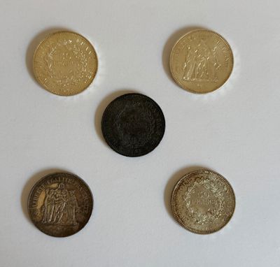 quatre types de pièces différents posés sur une surface blanche