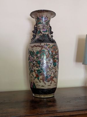 un vase posé sur une table à côté d'une lampe