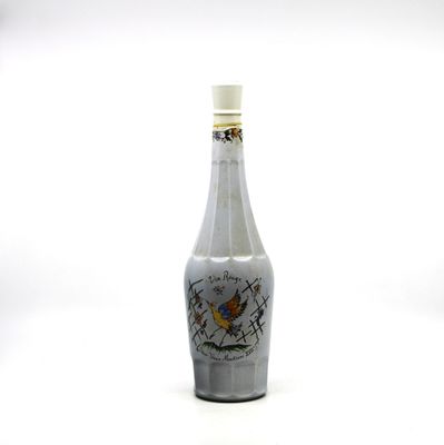 a bottle with a bird on it sitting on a table