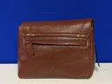 a brown leather purse sitting on top of a white table