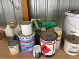 many cans of paint and cans of paint sitting on a table