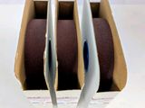 three rolls of cloth in a box on a table