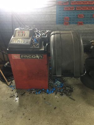 une machine qui se trouve dans un garage, à côté d'un tas de pneus