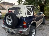une voiture garée sur un parking à côté d'un arbre