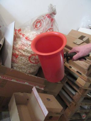 un seau rouge posé sur une pile de cartons