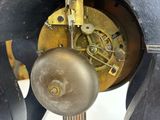 a close up of a clock with a pendulum on it