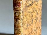 un vieux livre posé sur une table à côté d'un fond gris