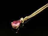 un collier en or orné d'un rubis en forme de cœur sur fond noir