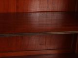 a wooden shelf with a book case on top of it