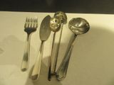 quatre cuillères, une fourchette et une cuillère posées sur une table